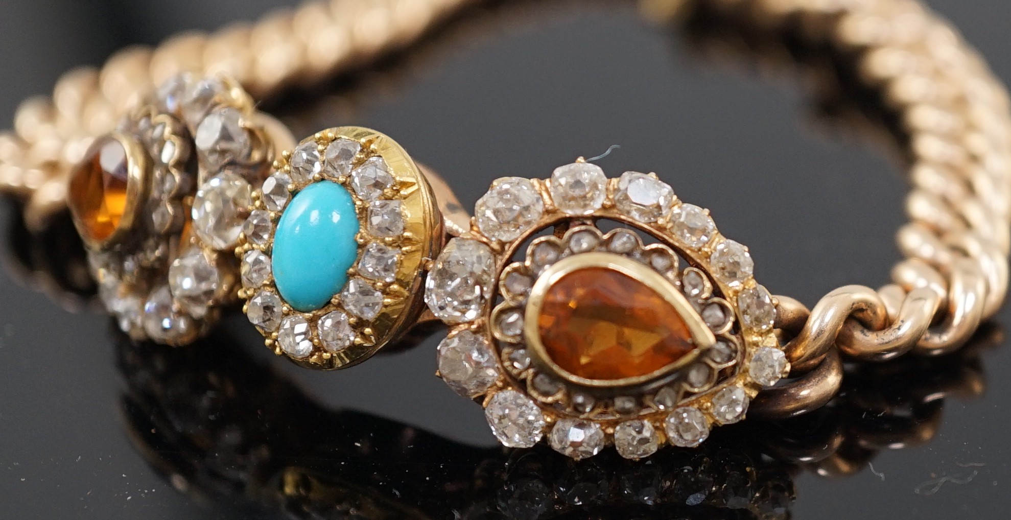 An Edwardian 15ct gold, citrine, turquoise and diamond set triple cluster set curblink bracelet